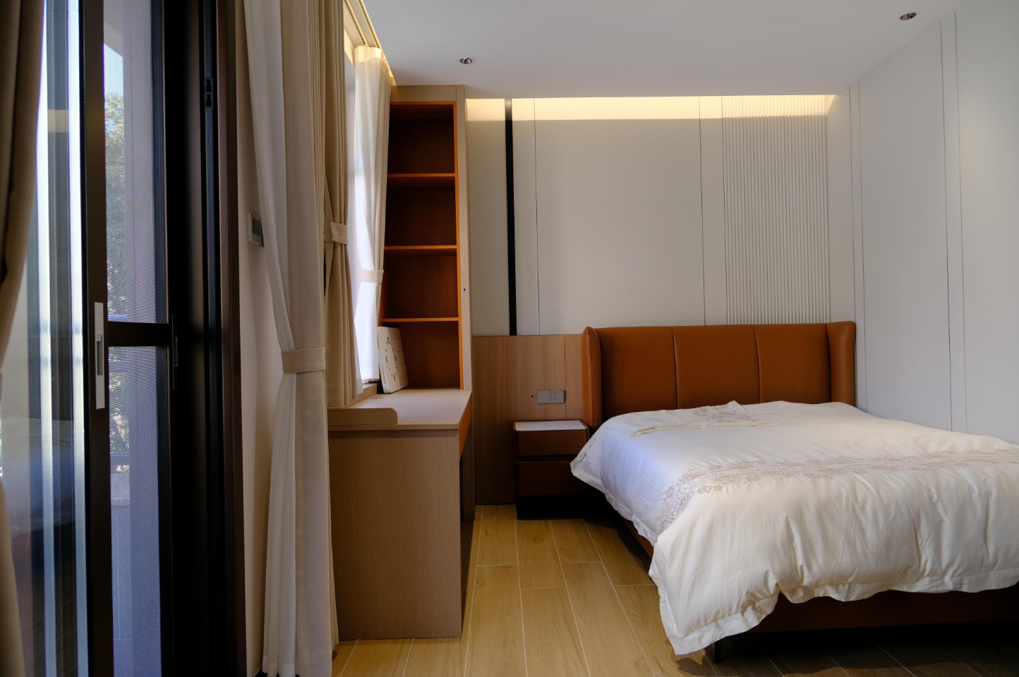 Bedroom with leather headboard and window-seat joinery